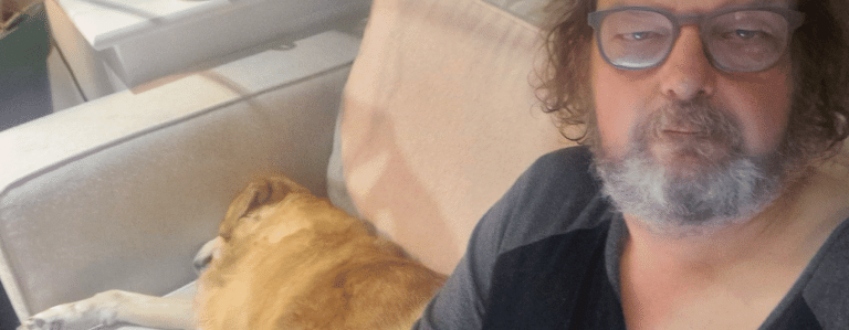 Del relaxing beside a dog during an overnight house sit in Whetstone N20